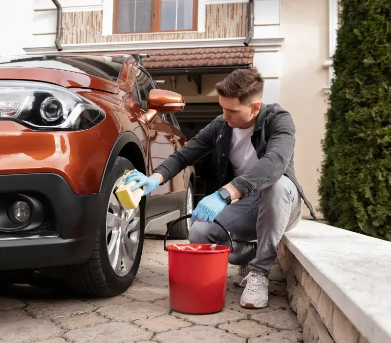 Lavage auto à domicile Védrines-Saint-Loup : professionnel intervenant sur un véhicule